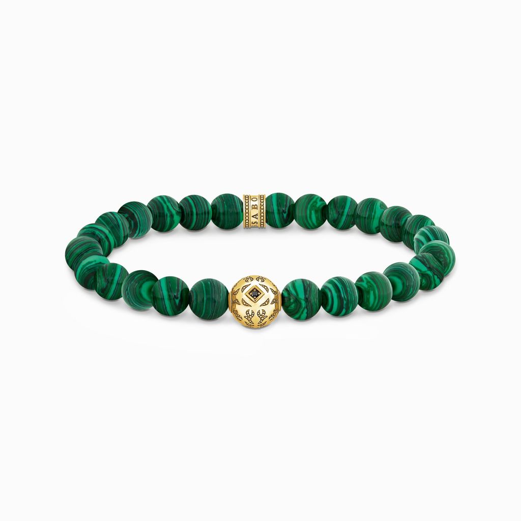 A bracelet with green beads and a gold centerpiece, displayed on a white background.