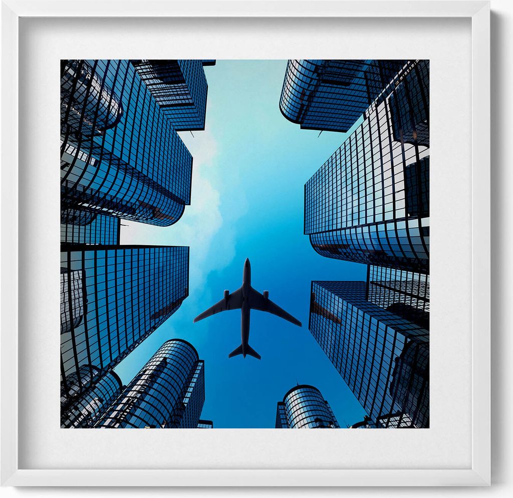 Flugzeug über Gebäuden– Wandbild mit Rahmen – Gerahmtes Bild – Wanddekoration – 50x50 cm – Weiß Rahmen
