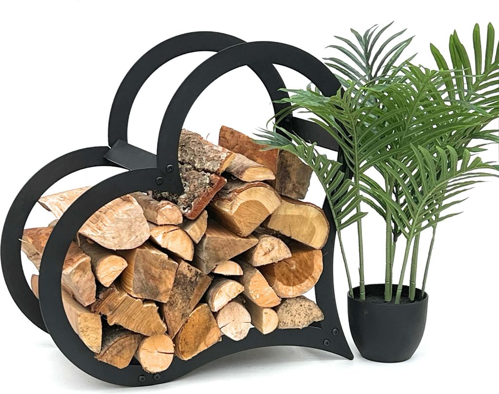 A black metal heart-shaped firewood rack filled with logs, placed next to a potted plant.