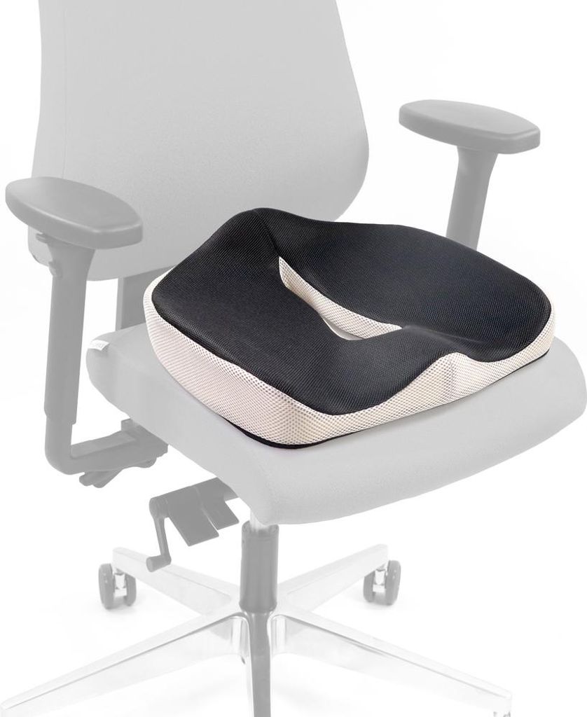 A black and white orthopedic seat cushion is placed on a chair.