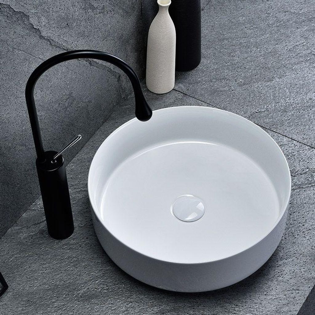 A modern bathroom sink with a black faucet.