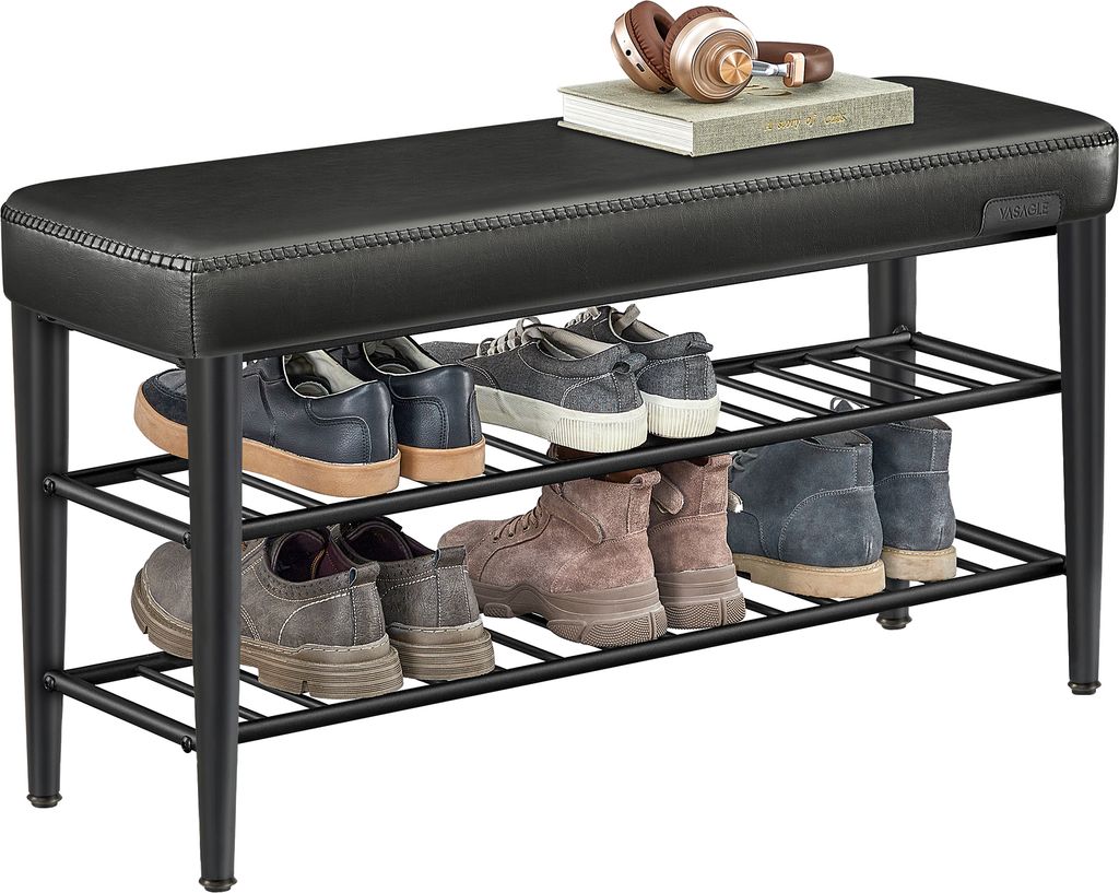 A black upholstered shoe bench with three shelves filled with shoes and boots. A pair of headphones and a book are on top of the bench.