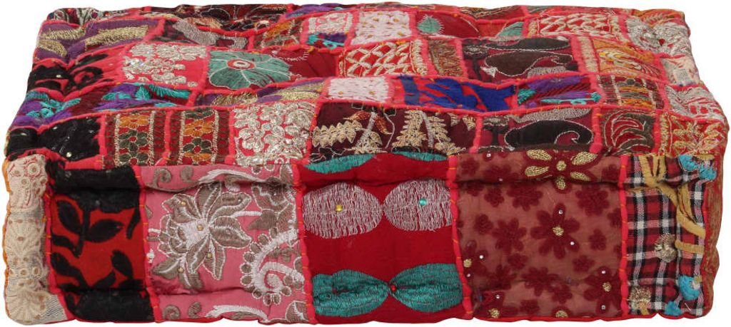 A close-up, straight-on view of a rectangular pouf with a patchwork design.