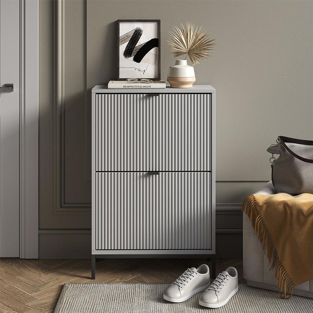 A hallway or entryway scene featuring a shoe cabinet, artwork, and decorative items.