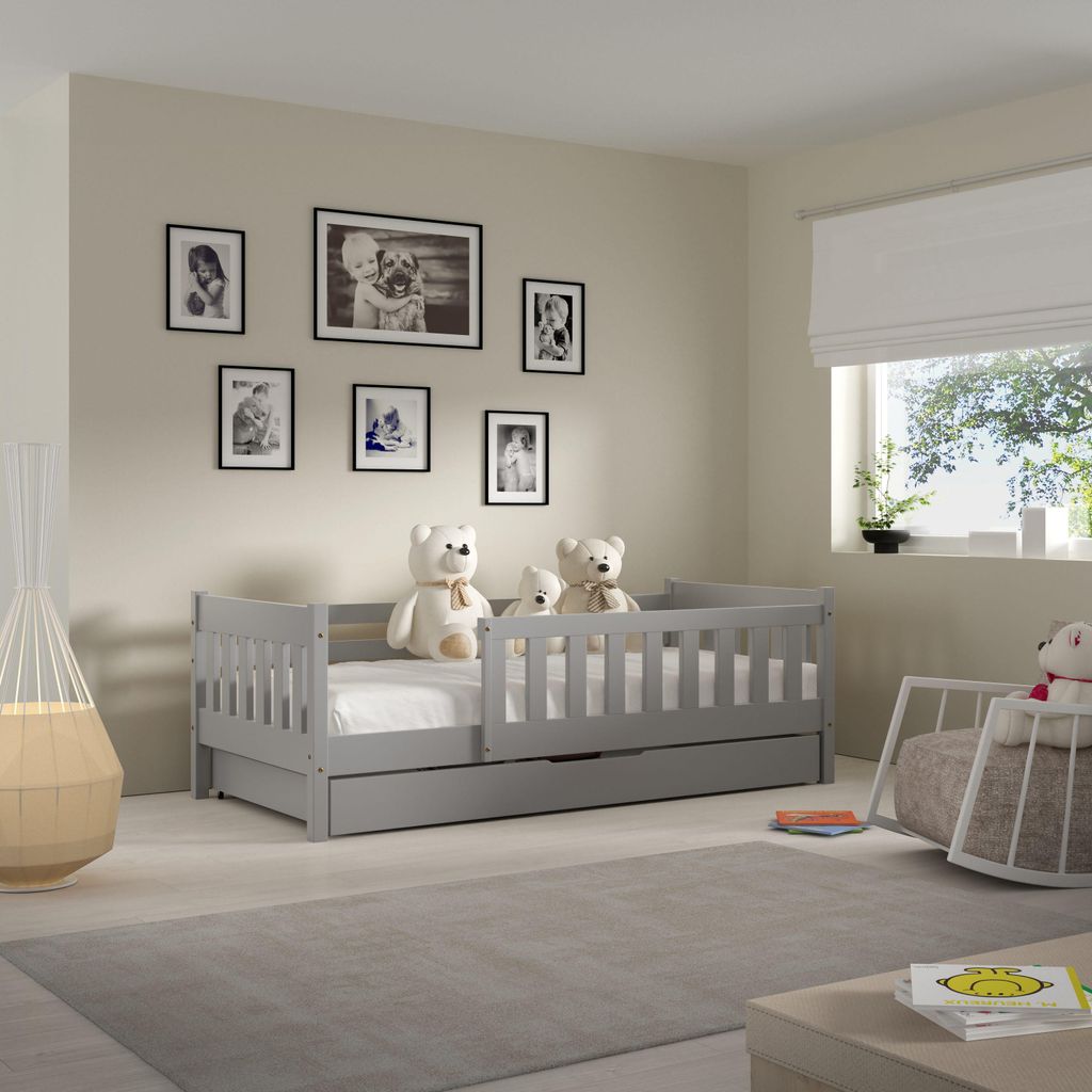 A child's bedroom with a bed, teddy bears, and framed pictures on the wall.