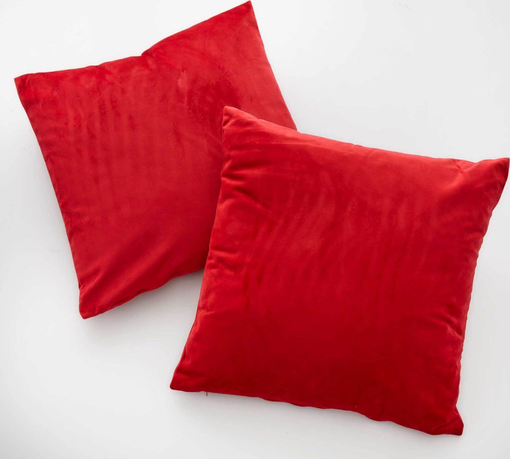 Two red square pillows are placed on a white background.