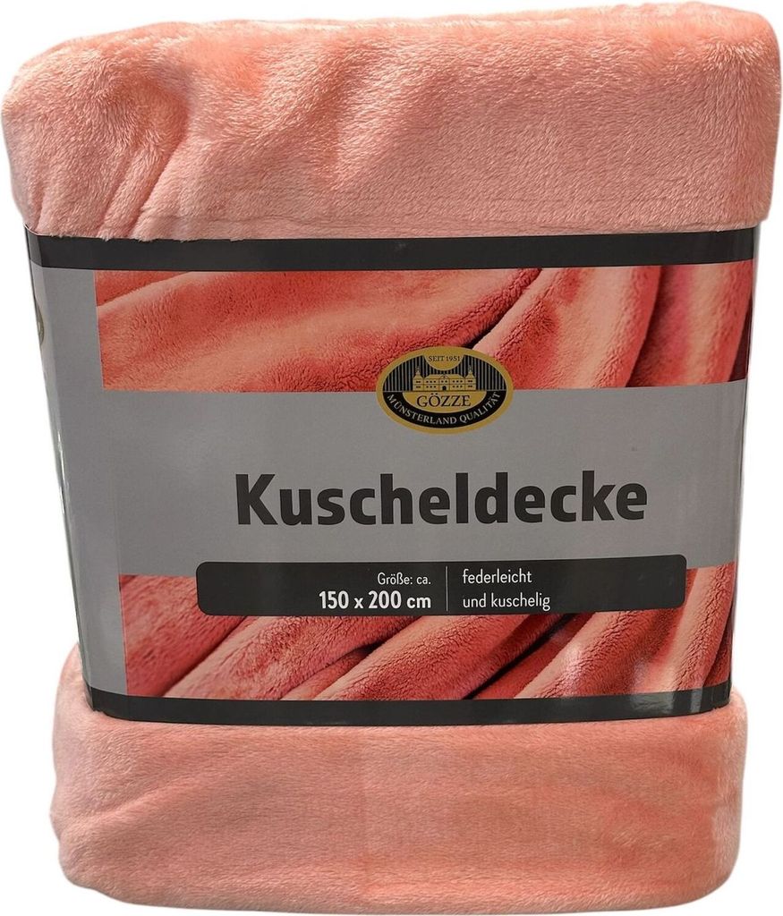 A pink blanket is folded and presented with its packaging.