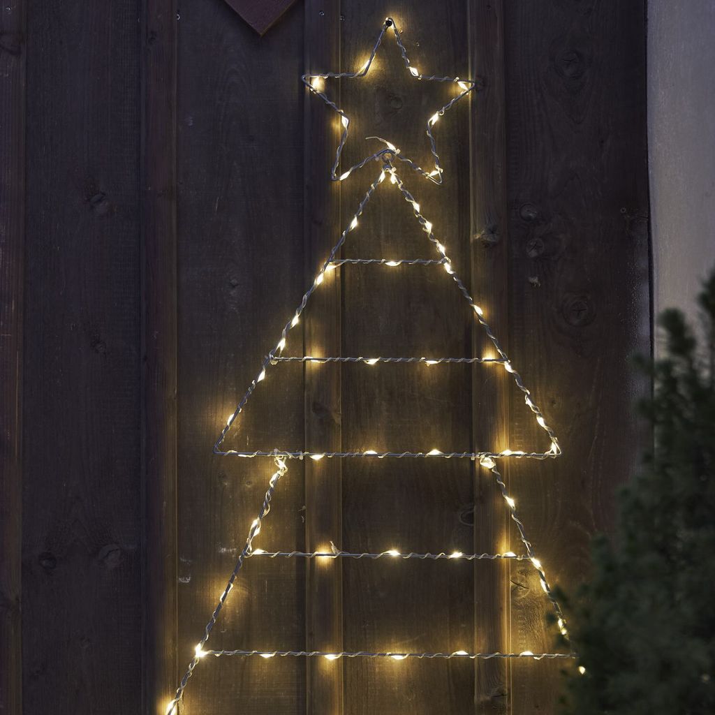 A string of lights in the shape of a Christmas tree with a star on top, mounted on a wooden wall.