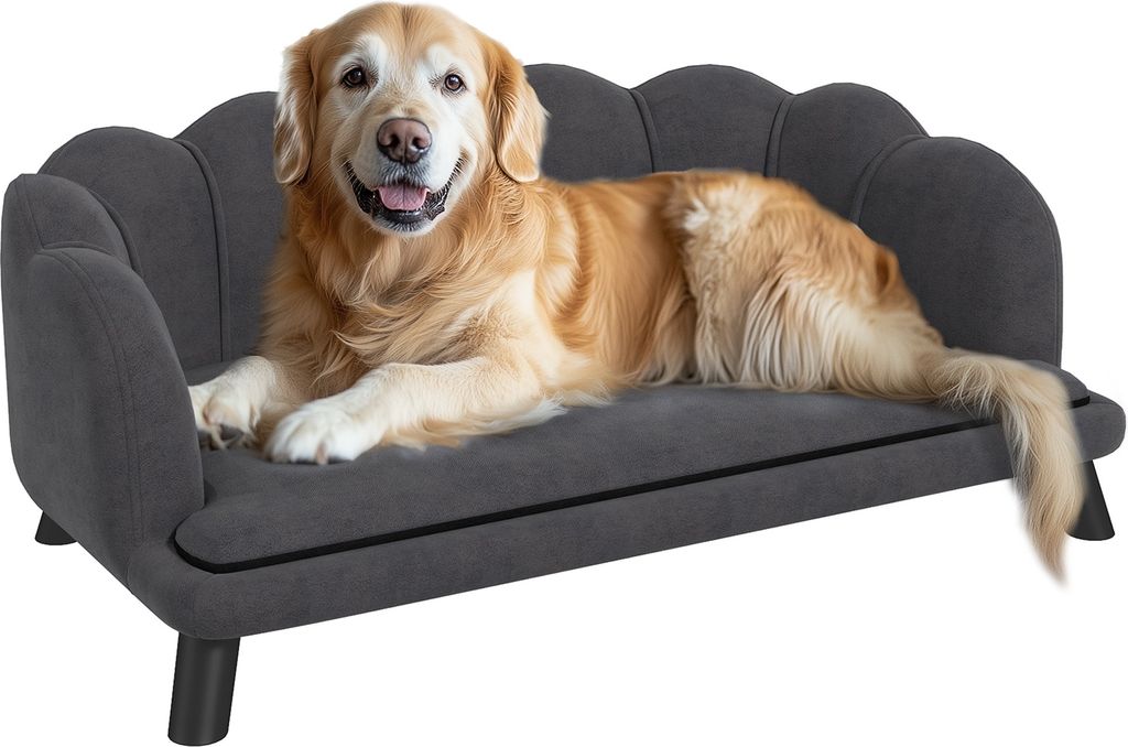A golden retriever dog is lying on a dark gray dog sofa.