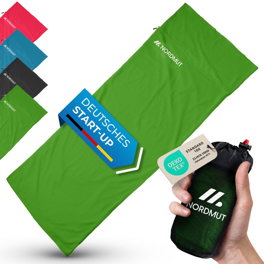 A green sleeping bag is laid out diagonally, with several other colored sleeping bags visible in the background. A hand holds a small, dark green pouch with a tag attached. Promotional graphics are overlaid on the sleeping bag.