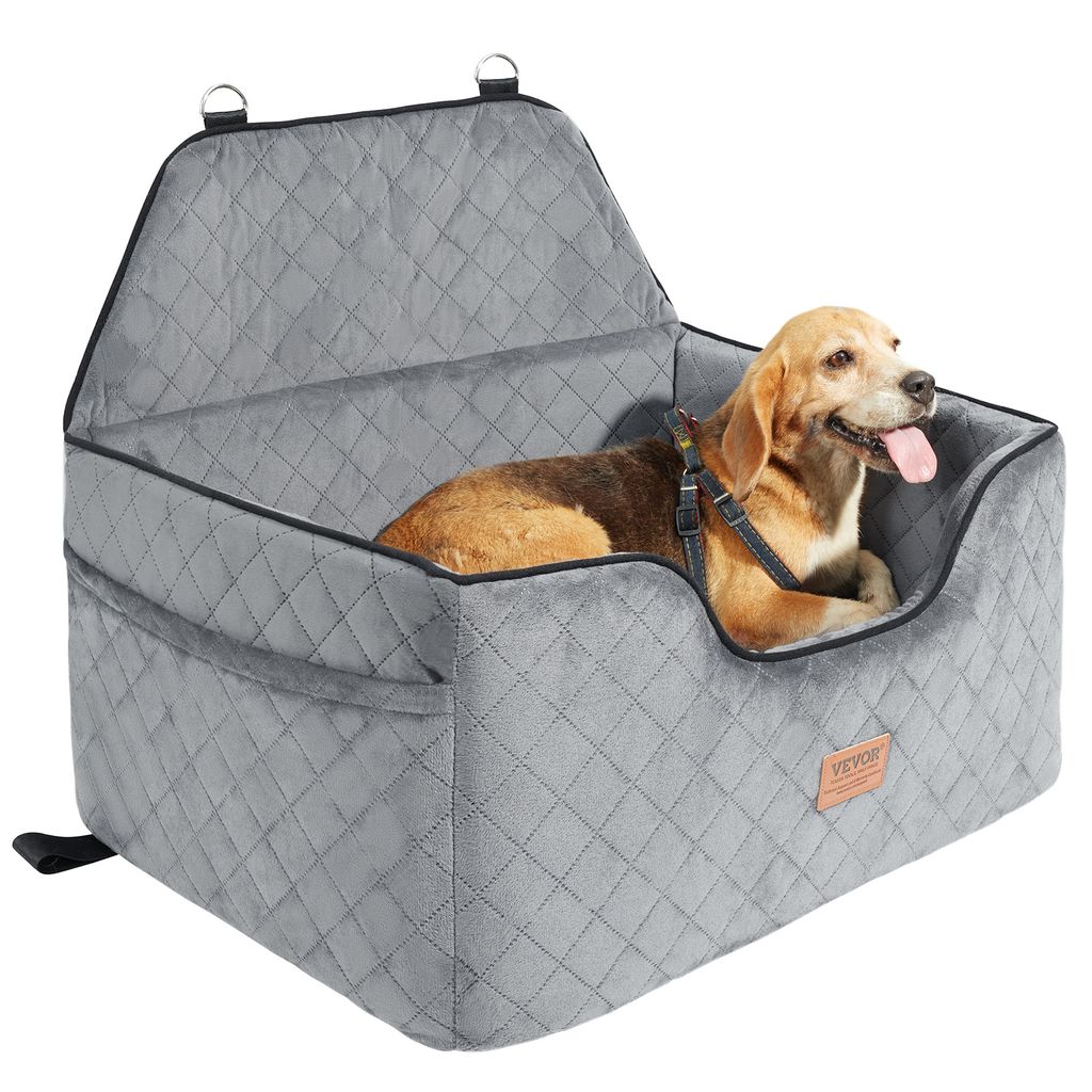 A dog is sitting in a gray pet car seat.