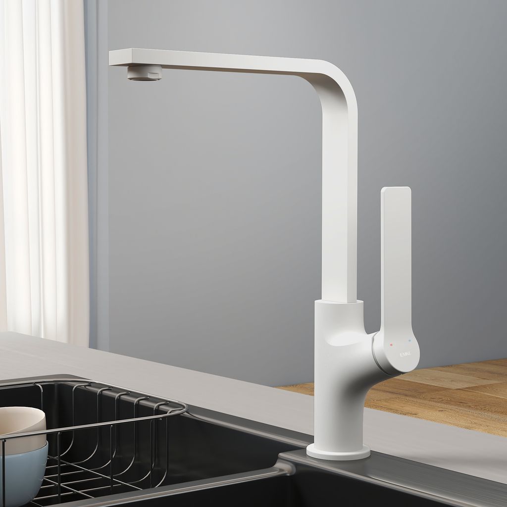 A white kitchen faucet is shown in a modern kitchen setting, next to a sink with a dish rack.