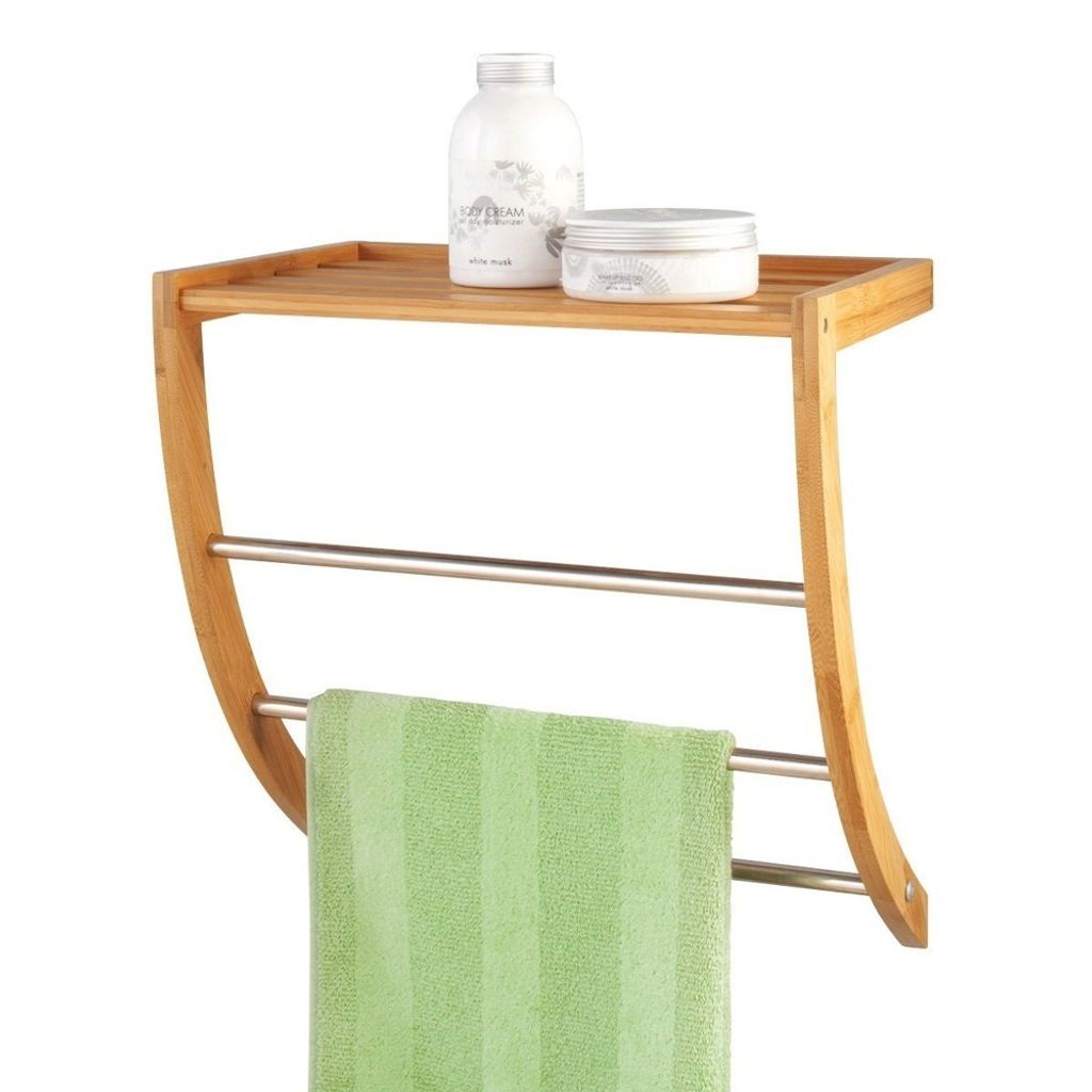 A bamboo and metal towel rack with a green towel hanging on it, and two toiletries on the top shelf.