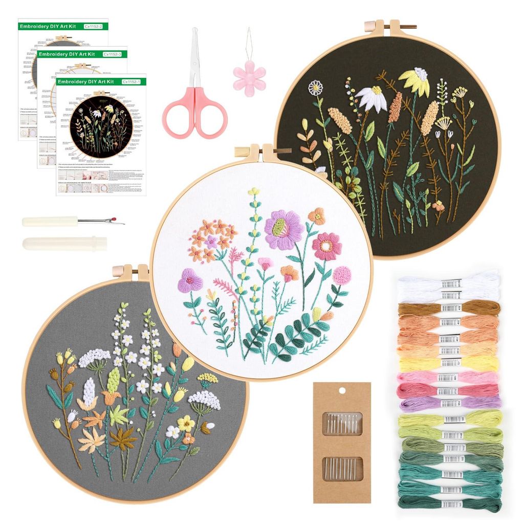 A collection of embroidery kits with floral patterns, including hoops, threads, needles, and instructions.