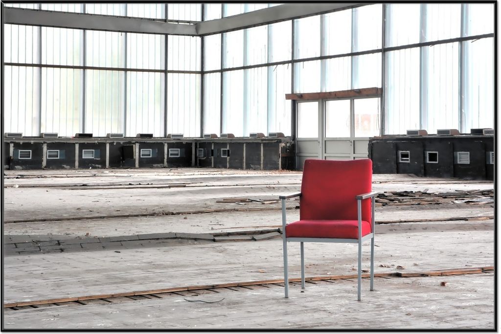 Wallario Wandbild Stille und Leere - ein einsamer roter Stuhl in einer alten Halle, Größe: 61 x 91,50 cm, Poster mit schwarzem Aluminiumrahmen