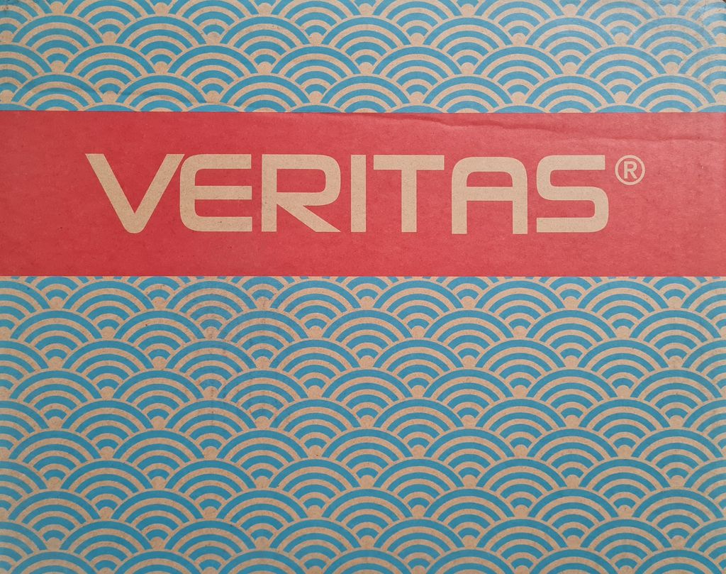 A close-up of a red band with the word VERITAS in white text, set against a background of blue and tan wave-like patterns.