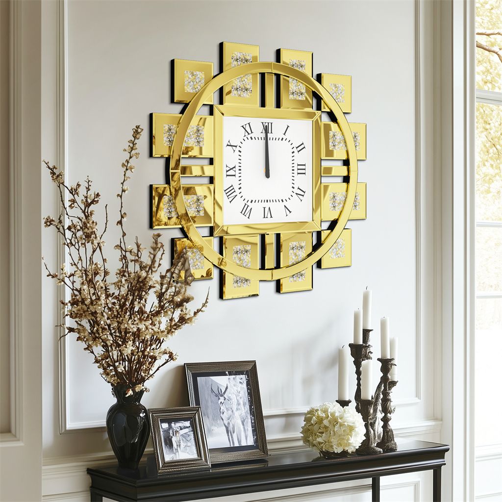 A decorative wall clock with Roman numerals is displayed on a wall above a console table with framed pictures and candles.