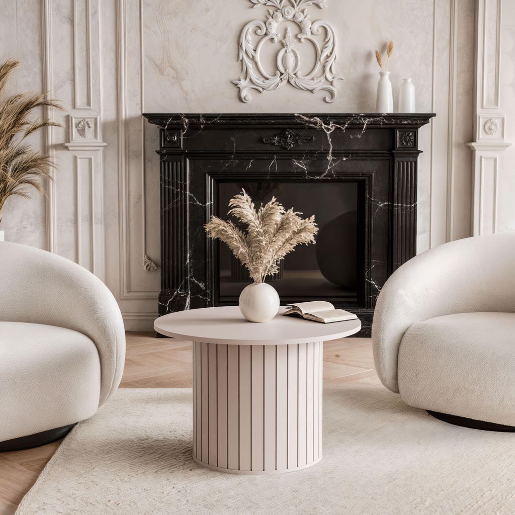 A living room scene with a fireplace, two armchairs, and a coffee table.