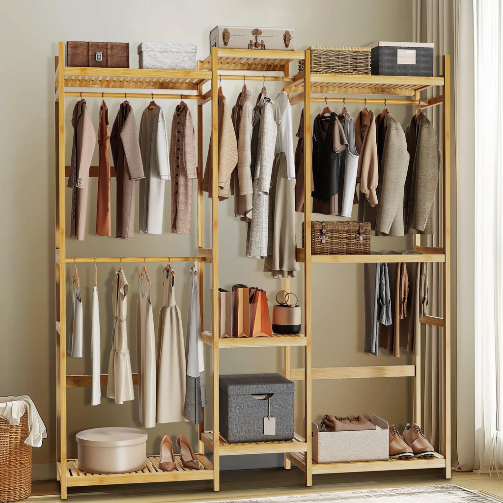 A bamboo wardrobe stand with clothes hanging on it and storage boxes on shelves.