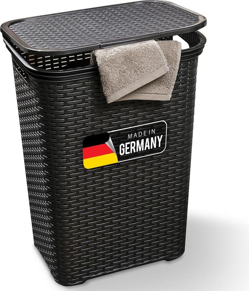 A black laundry basket with a lid and two folded towels hanging from the edge. A "Made in Germany" label is visible on the front.