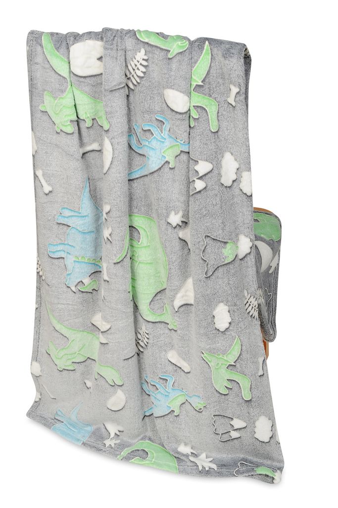 A folded blanket with a dinosaur pattern is draped over a chair.
