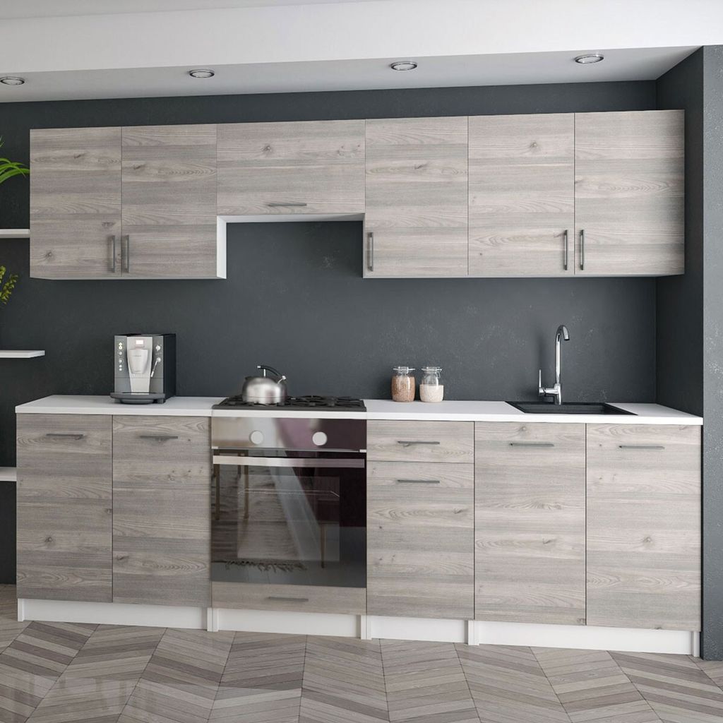 A modern kitchen with light wood cabinets and a dark gray wall.
