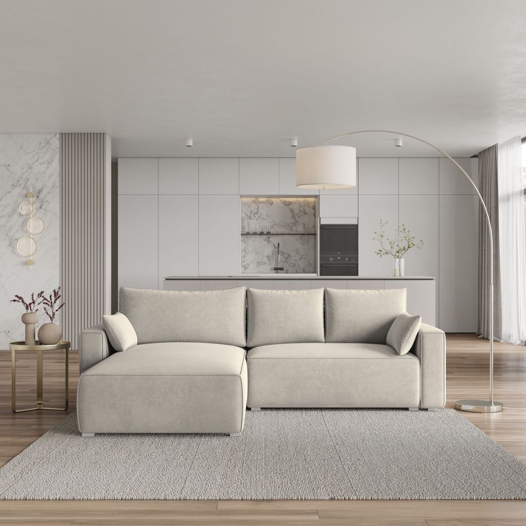 A modern living room with a sofa and kitchen in the background.