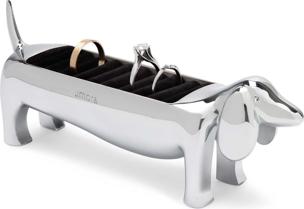 A silver dachshund-shaped ring holder with rings inside, on a white background.