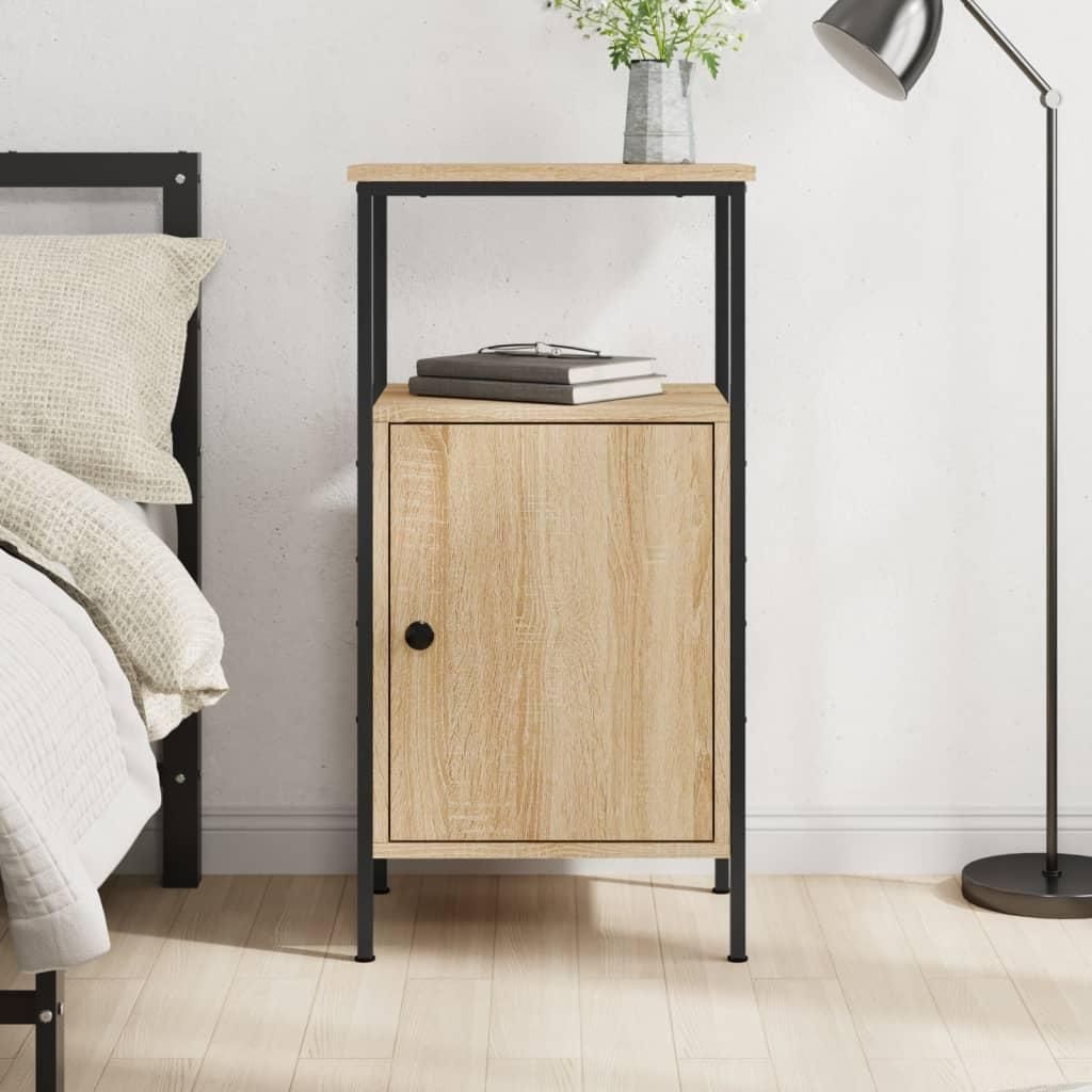 A wooden nightstand with a black metal frame is placed next to a bed. There is a lamp and a vase with flowers on top of the nightstand.