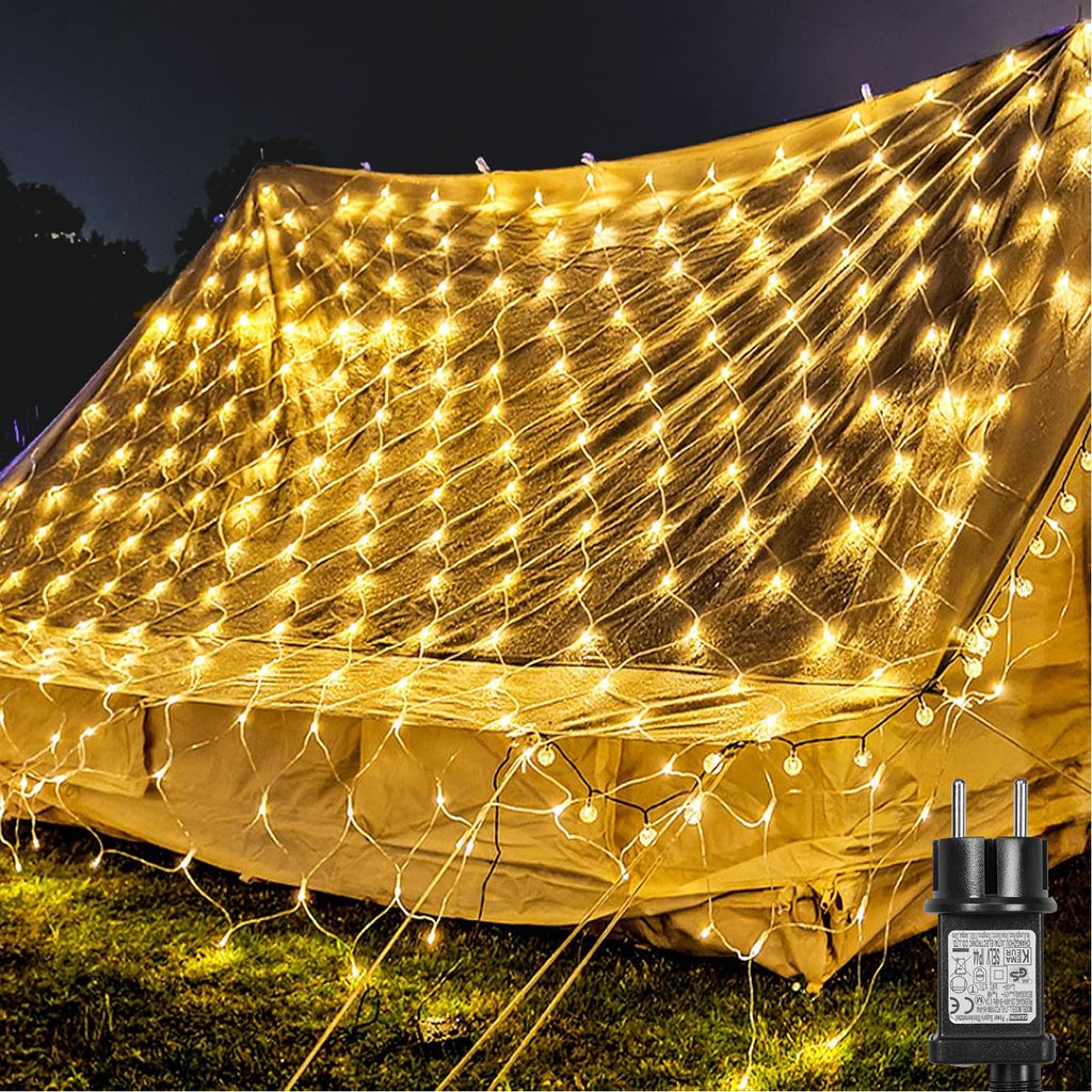 A tent covered in warm white net lights at night.