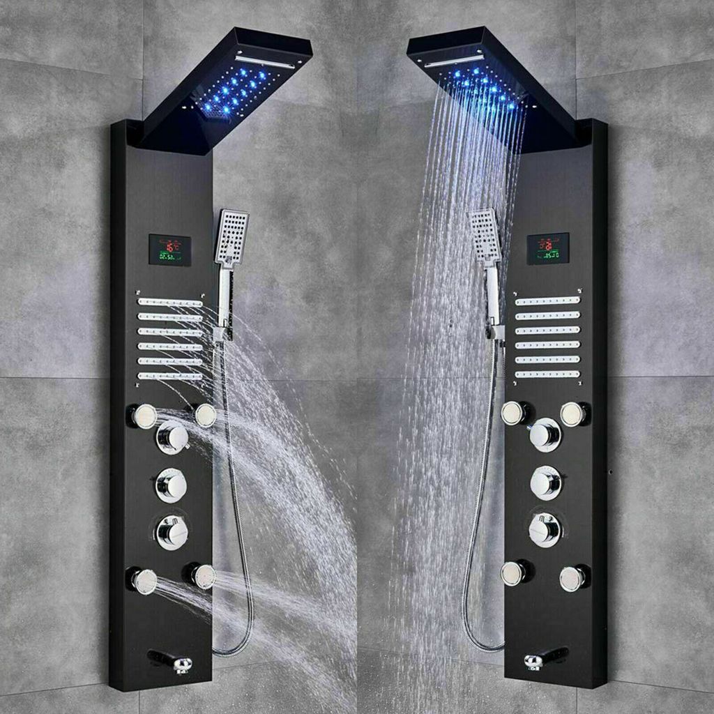 Two black shower panels with LED lights and multiple shower heads are mounted on a gray tiled wall.