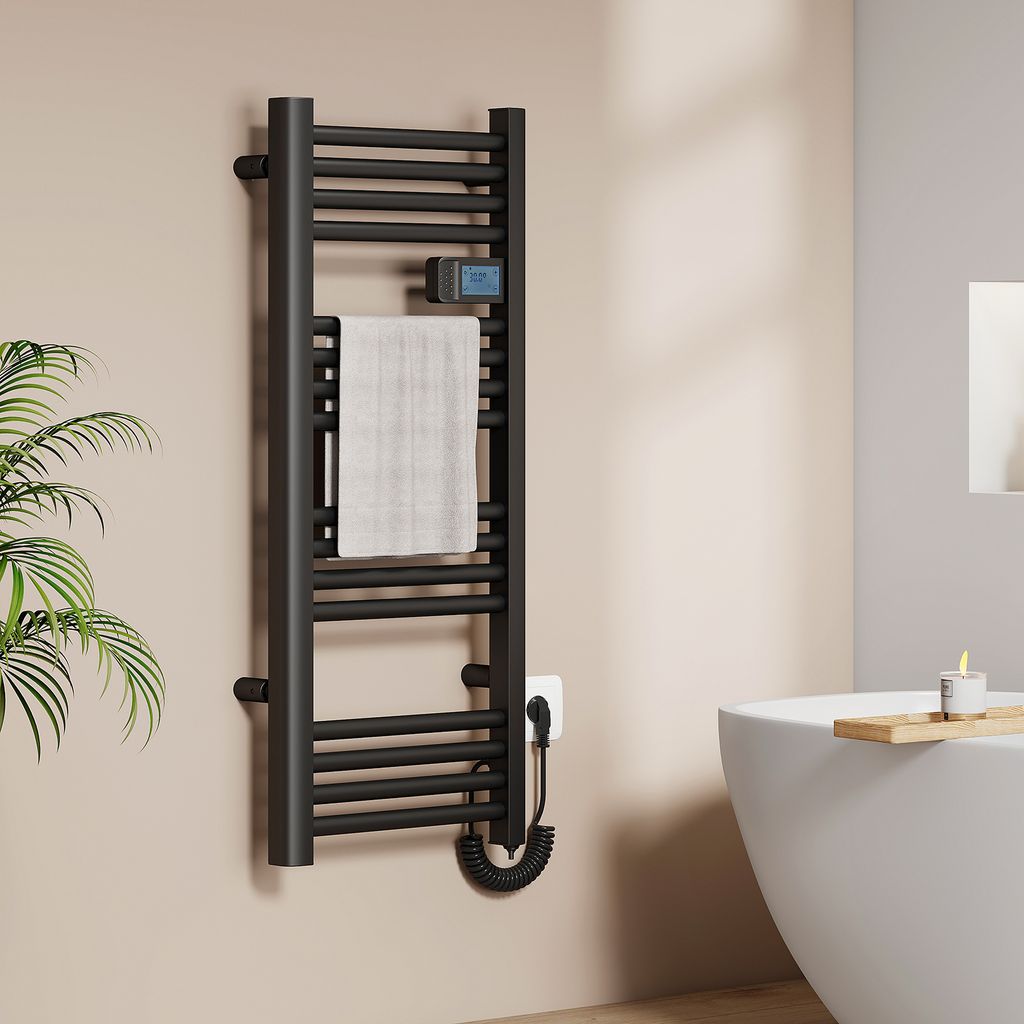 A black electric towel radiator with a white towel hanging on it, mounted on a beige wall next to a white bathtub.