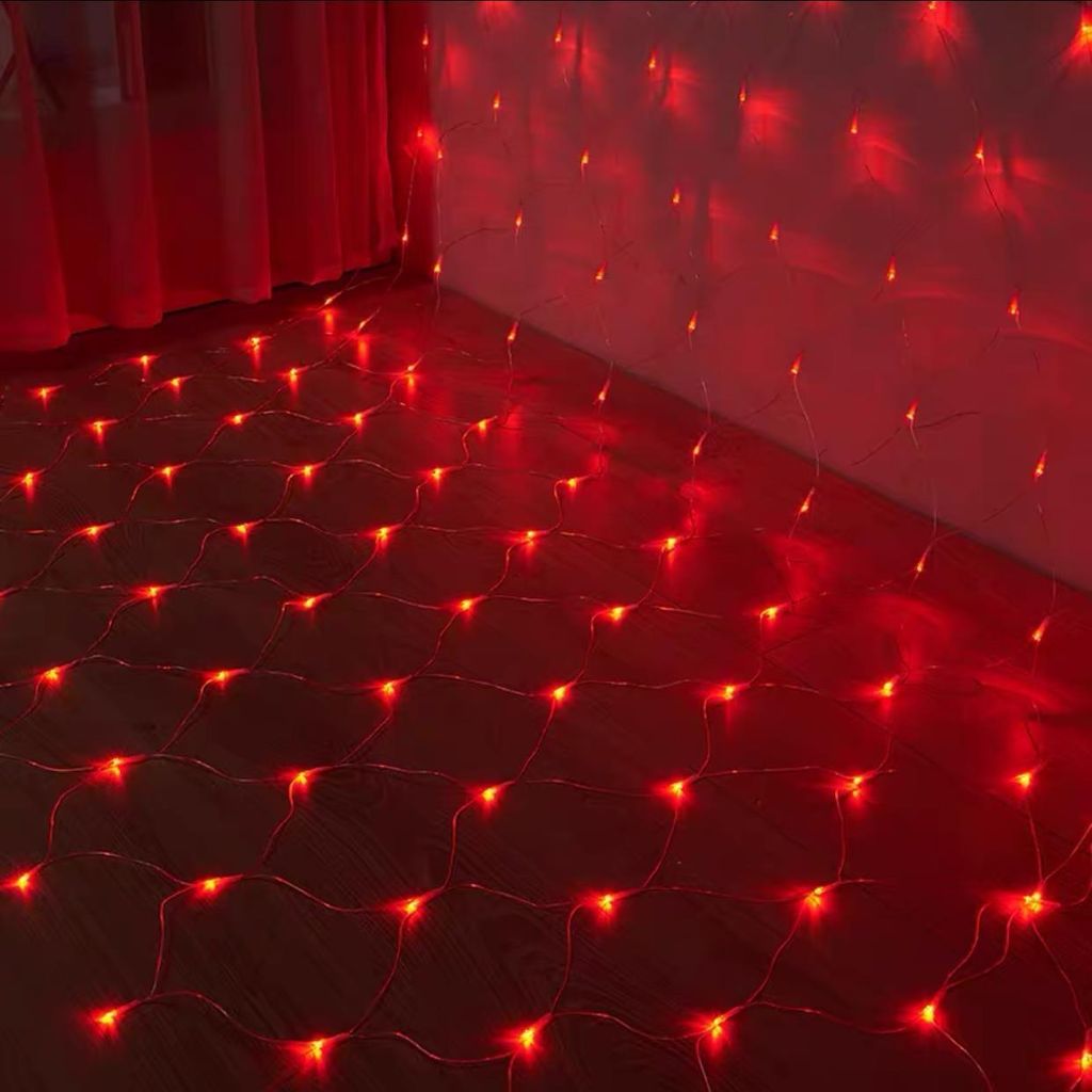 Red LED net lights are draped across a floor and up a wall, casting a warm glow.