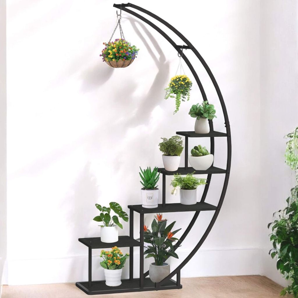 A black metal plant stand with multiple tiers, holding various potted plants, against a white wall.