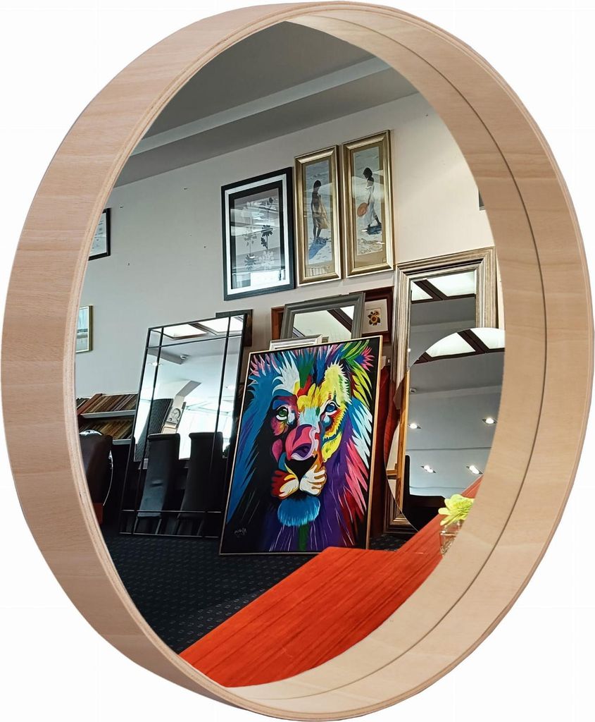 A round mirror with a wooden frame reflecting a room with several framed pictures and a colorful painting of a lion.