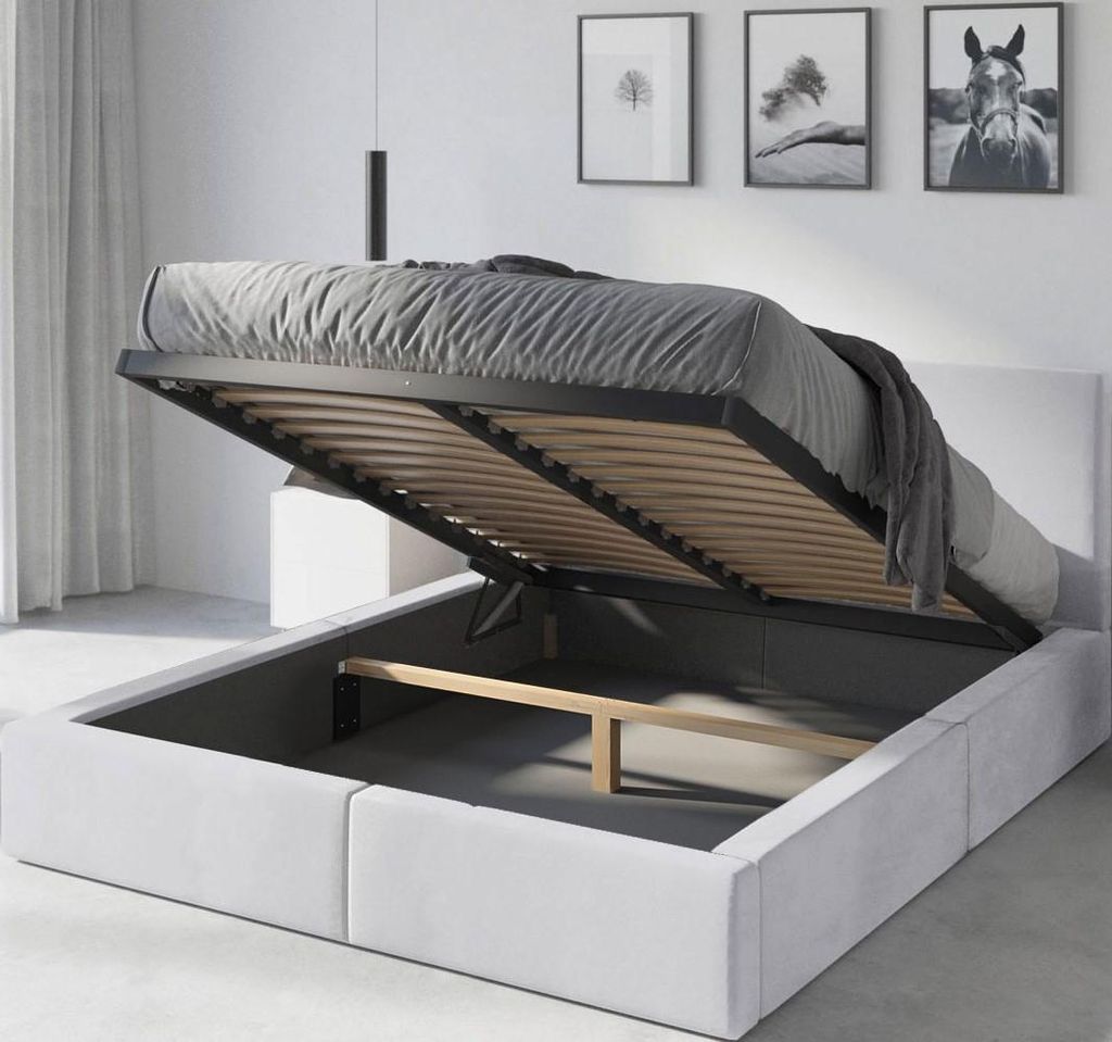 A bed with its storage compartment open, revealing the mattress support and storage space.