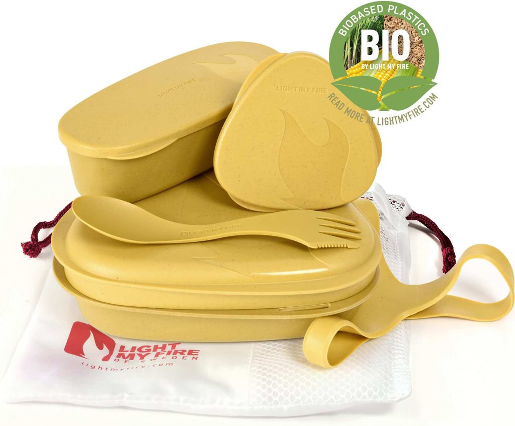 A set of yellow camping meal containers and utensils, neatly arranged on a white cloth bag.
