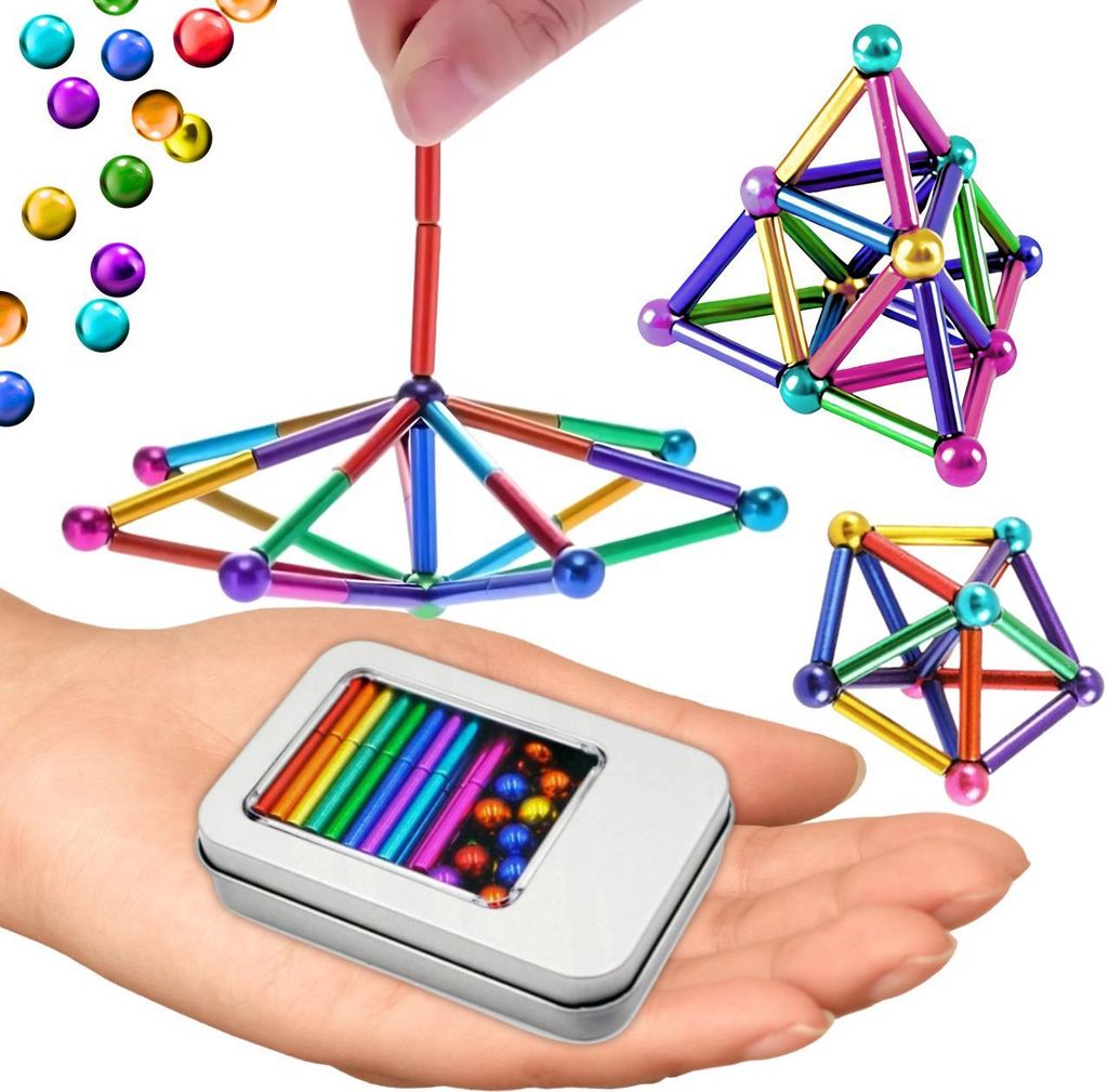 A hand holding a tin of magnetic balls and rods, with several magnetic structures built from them in the background.