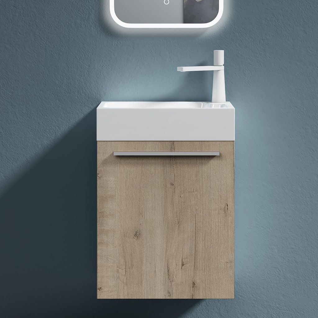 A modern bathroom vanity with a white sink and a wood-grain cabinet against a blue wall.