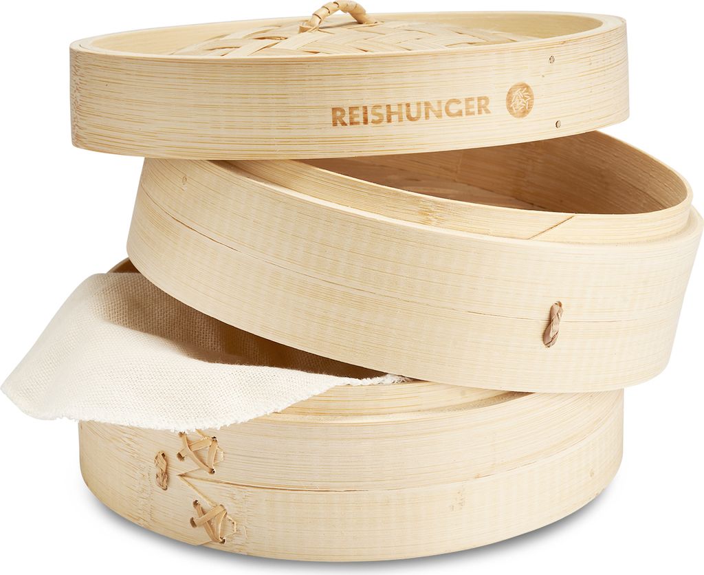 A stack of bamboo steamers with a piece of cloth sticking out of one.