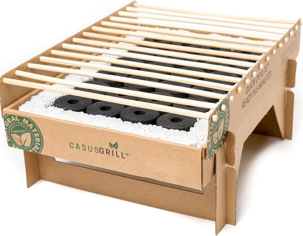 A disposable cardboard grill with charcoal and wooden grates, set against a white background.