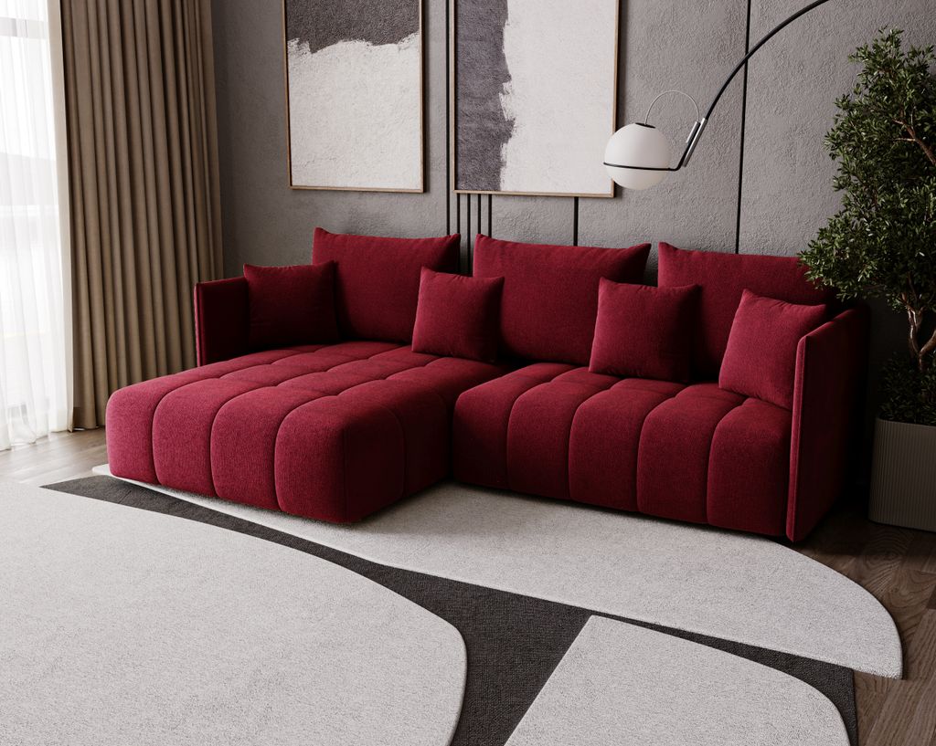 A modern living room with a red sectional sofa, abstract art on the wall, and a large rug.