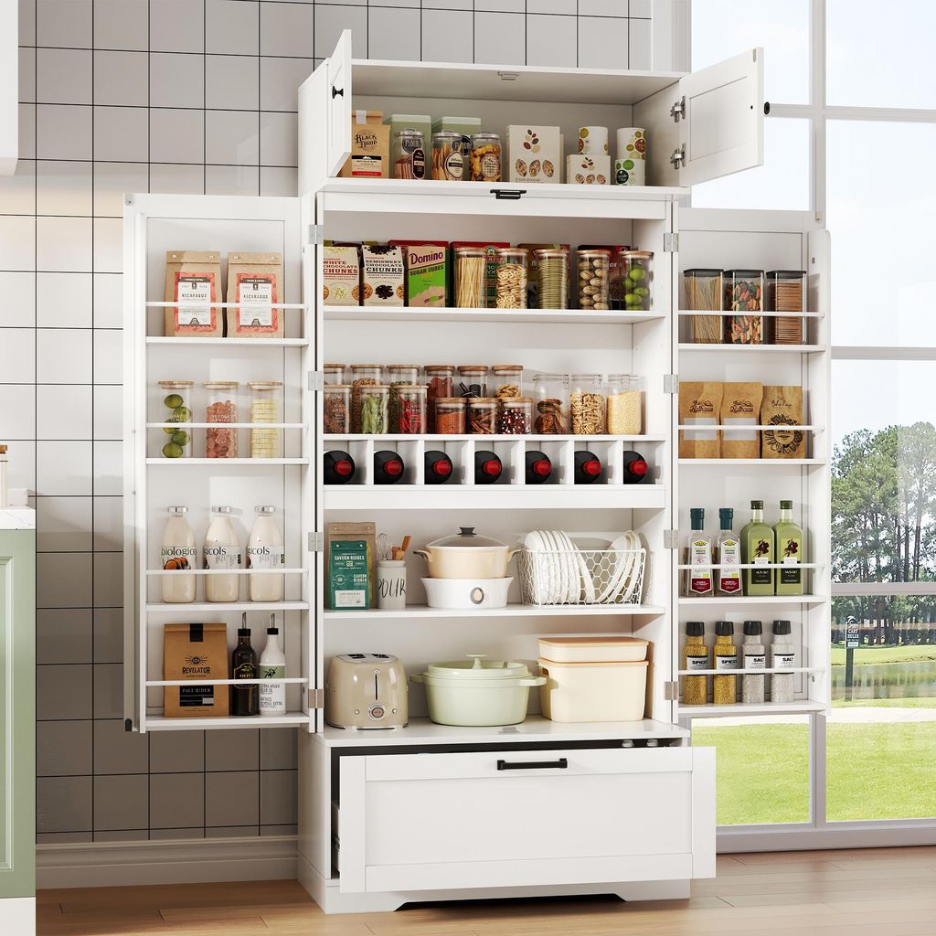 A white buffet cabinet filled with various kitchen items and food products, set against a tiled wall and a window view of trees and water.