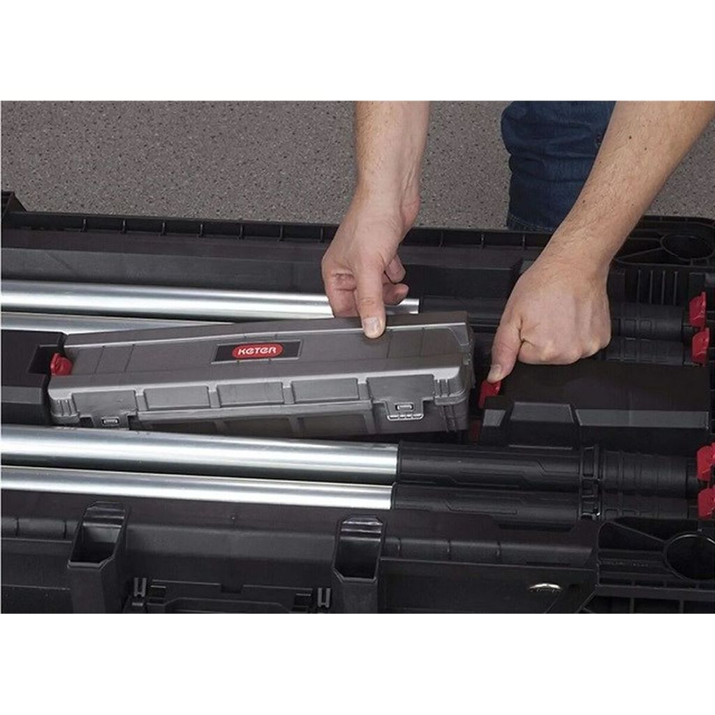 A person's hands are shown placing a tool case into a larger black storage container.