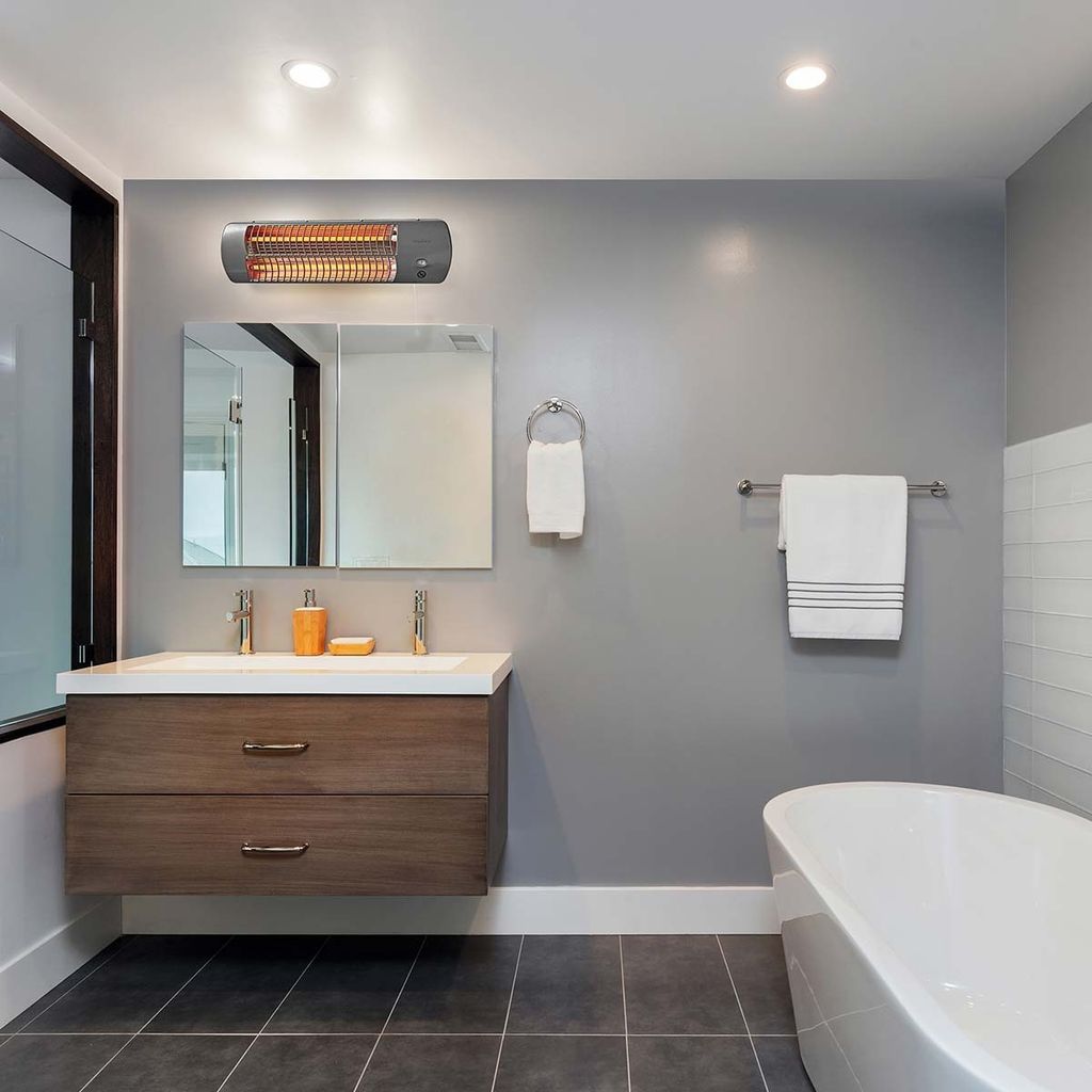 A modern bathroom with a vanity, bathtub, and a wall-mounted heater.