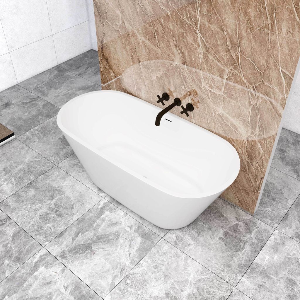 A freestanding oval bathtub in a modern bathroom with marble-like tiles.