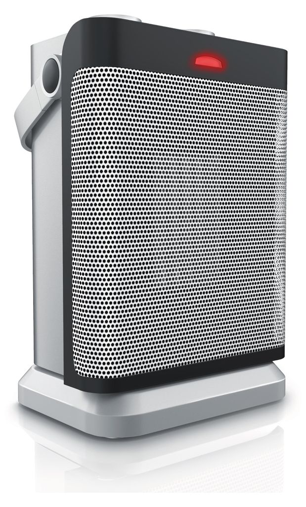 A product shot of a silver and black ceramic heater with a red indicator light on top, placed on a reflective white surface.