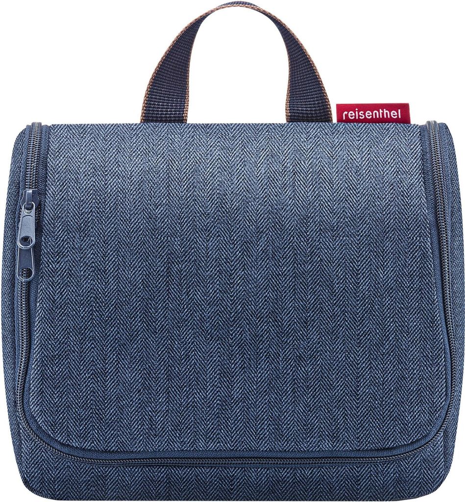 A blue toiletry bag with a herringbone pattern is shown against a white background.