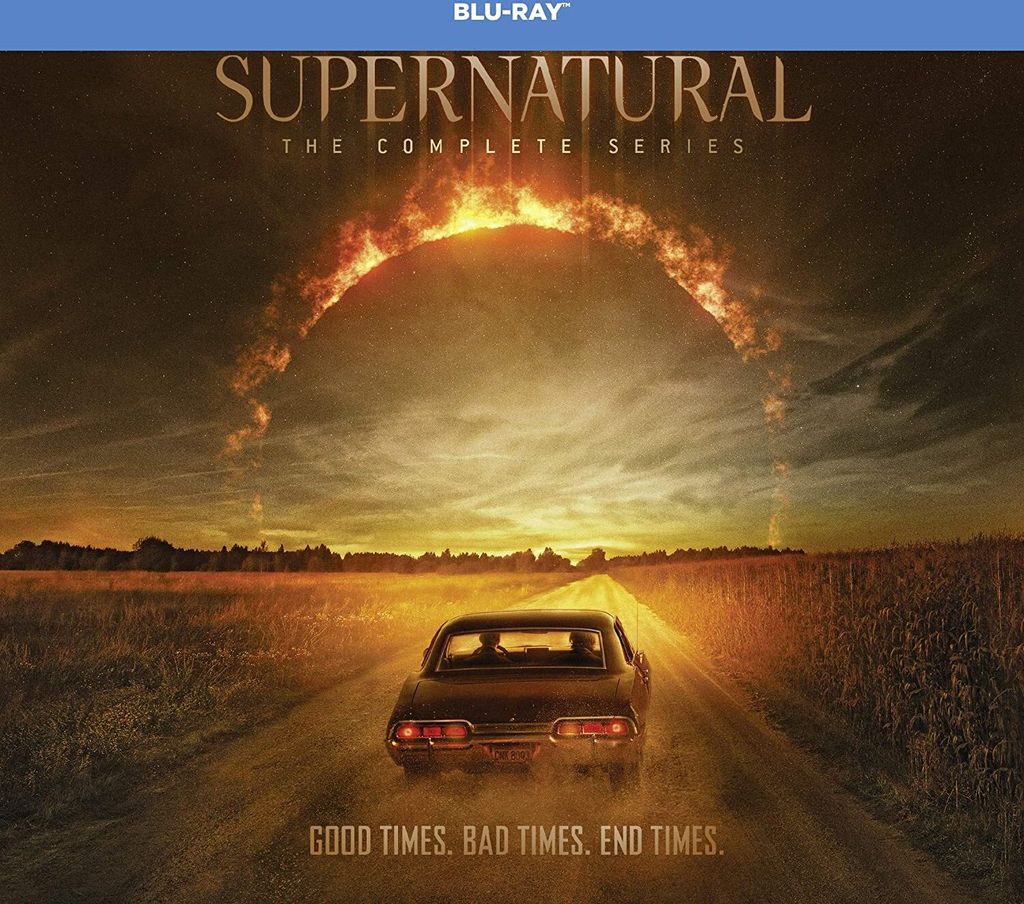 A car drives down a dirt road towards a fiery, circular phenomenon in the sky, with the text 'SUPERNATURAL THE COMPLETE SERIES' and 'GOOD TIMES. BAD TIMES. END TIMES.' displayed.
