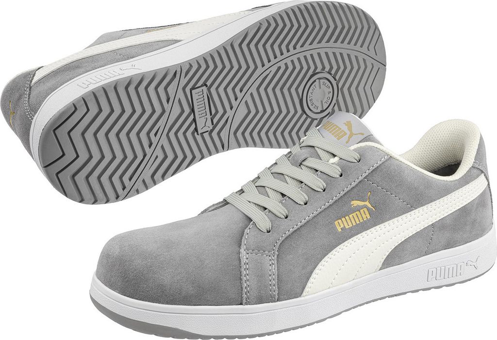 A pair of grey Puma safety shoes are displayed against a white background. One shoe is shown from the side, laced up, while the other is shown from the sole.
